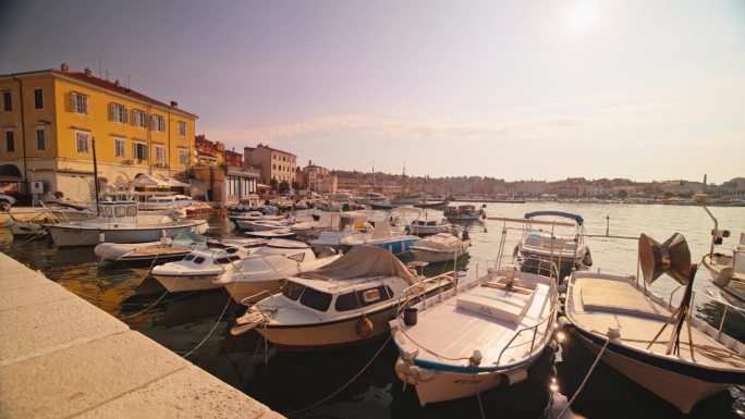 在阳光明媚的日子里，停泊在著名历史小镇港口的船只的SLO镜头。克罗地亚，罗维尼，伊斯特拉。
