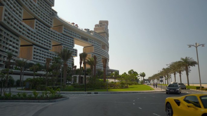 阳光明媚的一天迪拜城棕榈岛最著名的新现代酒店外部前方豪华汽车交通慢动作全景4k阿联酋