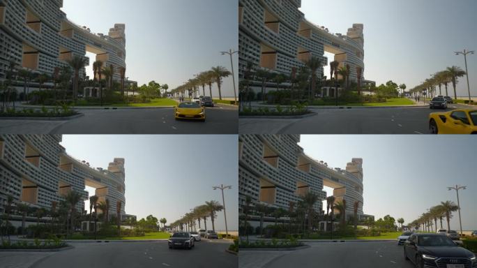 阳光明媚的一天迪拜城棕榈岛最著名的新现代酒店外部前方豪华汽车交通慢动作全景4k阿联酋