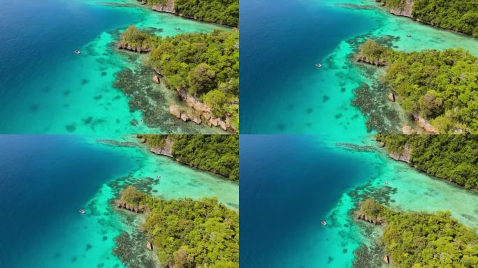 在潜水者探索的斐济隐蔽岛屿上，无人机在珊瑚礁上方升起。