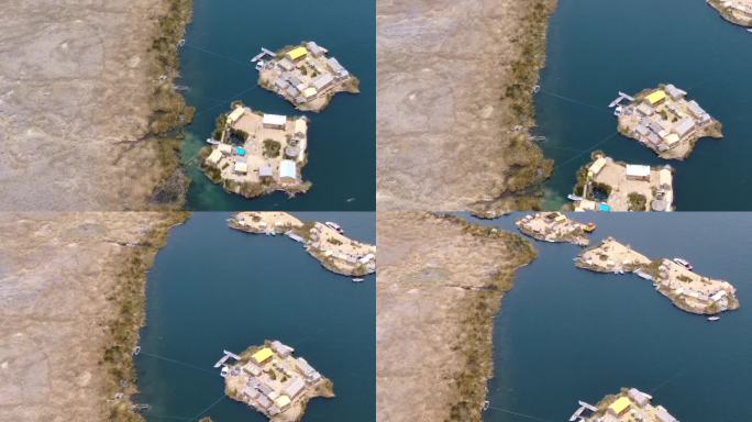 在一个阳光明媚的日子里，秘鲁的无人机鸟瞰图在普诺的提提卡卡湖的小岛上飞过huros定居点，上面有小船