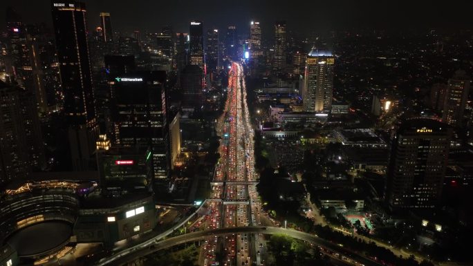夜间照亮雅加达市中心高流量街道道路交汇处航拍全景4k印度尼西亚