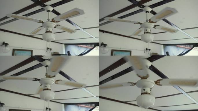 旧的白色吊扇，带电灯旋转和夏季降温，长叶片和两条开关链的电动吊扇，老式的房屋天花板