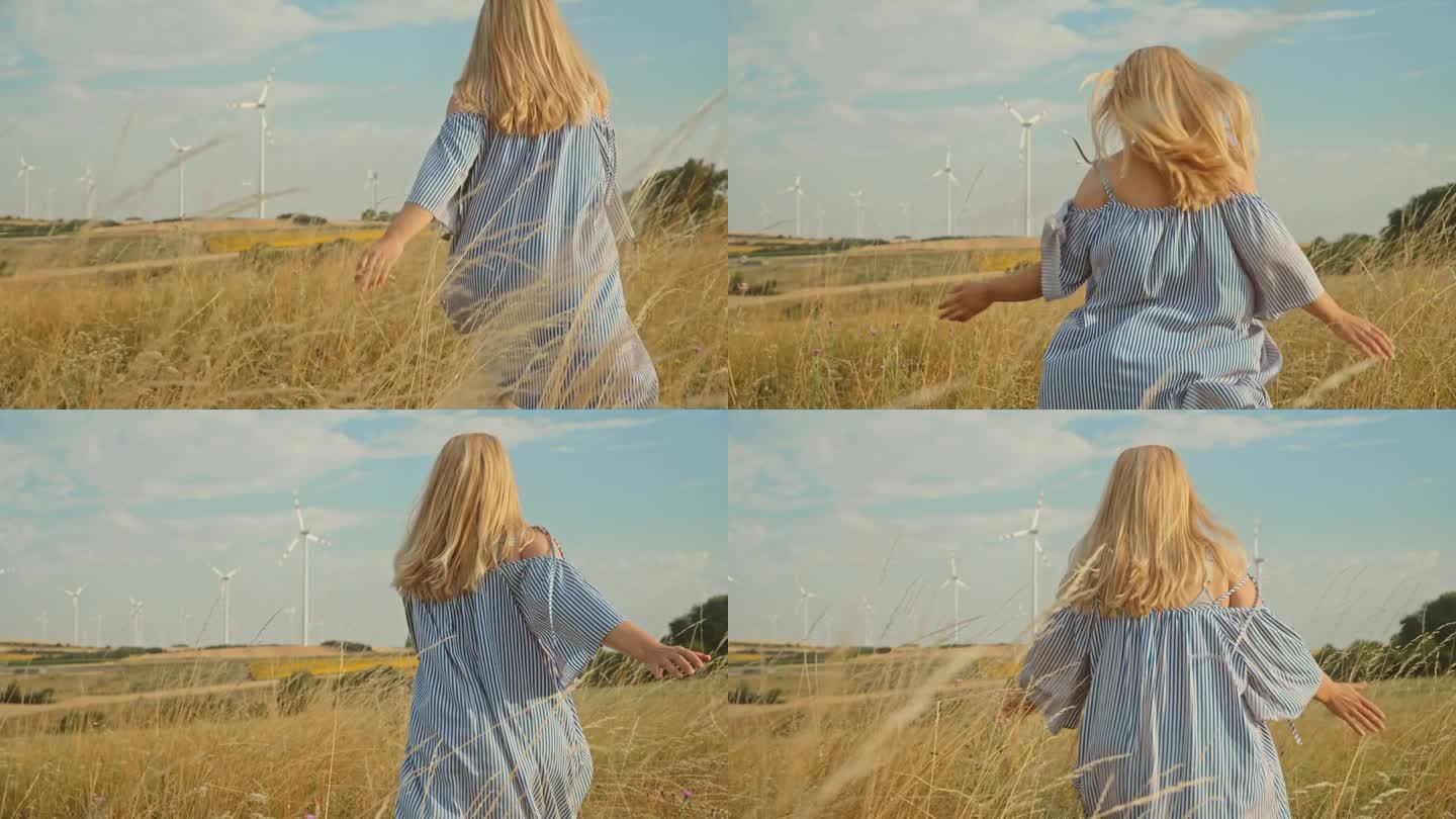 追逐明天:在金色草地和风力涡轮机中，女人的精神奔跑