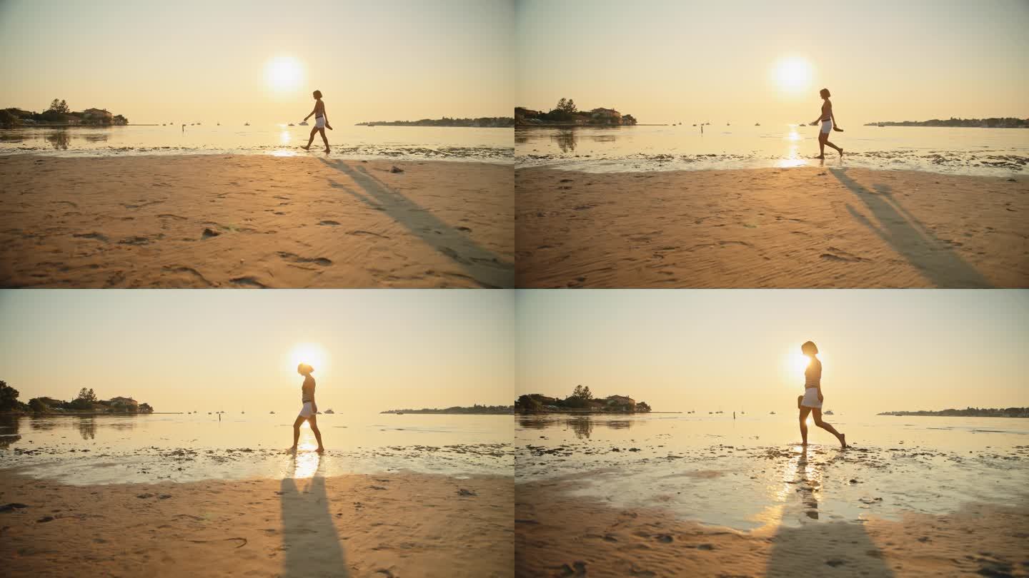 女子在沙滩上散步，享受假期中的日落