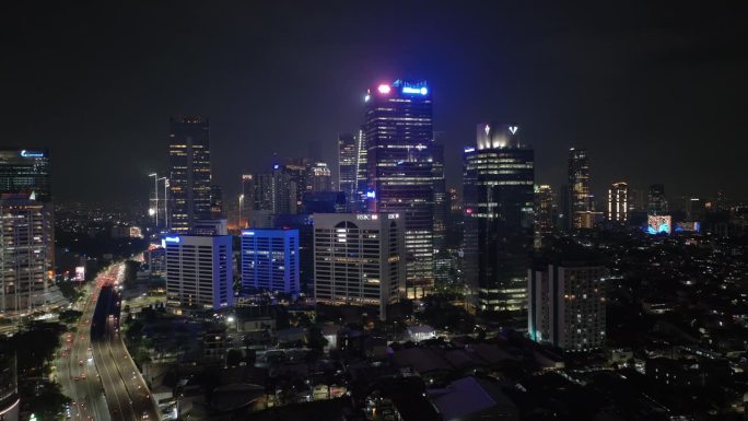 夜间照亮雅加达市中心的办公大楼交通街道道路航拍全景4k印尼