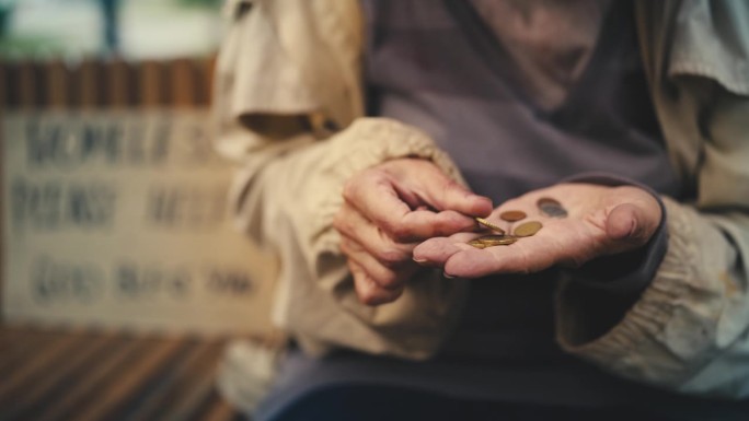 无家可归的老年妇女用手心数硬币，沿街乞讨，穷困潦倒