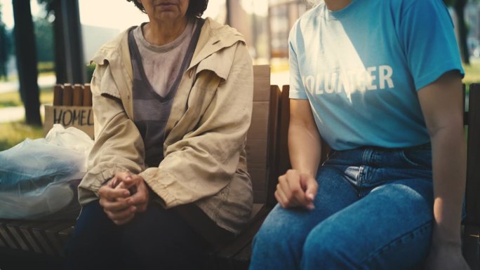 女志愿者与贫穷的无家可归的老年妇女交谈，社会救助