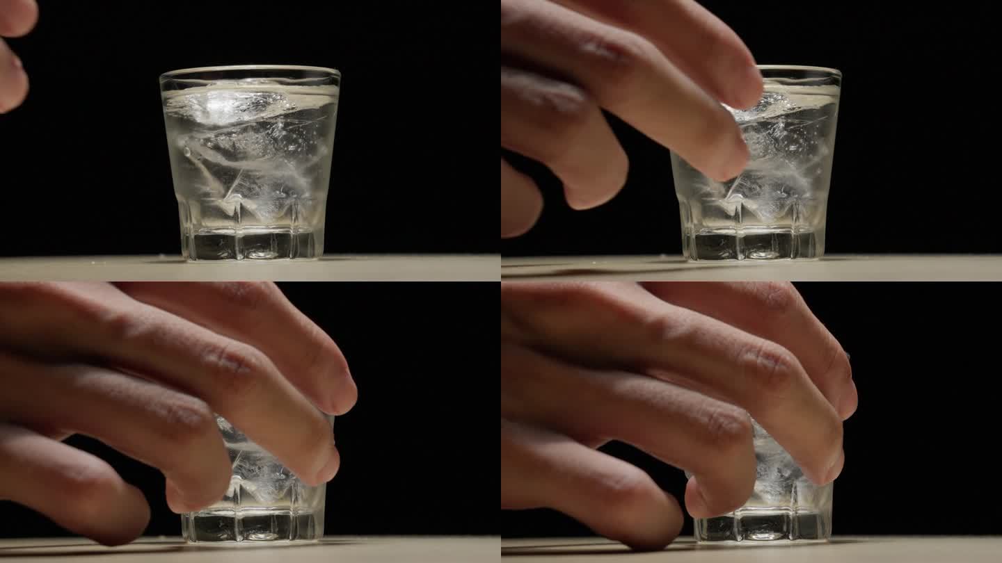 用小酒杯上的冰块用手挑酒。慢镜头特写
