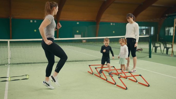 少帅女教练在体育会网球场训练小朋友迷你速度栏