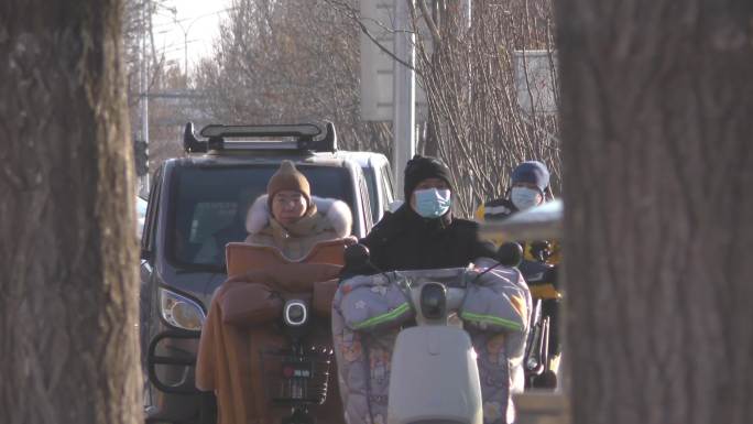 冬季车流骑行人文打拼城市遛弯送孩子上学
