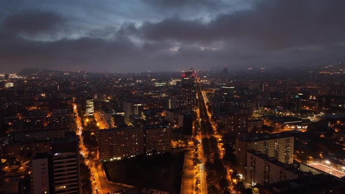 黄昏照明飞行在巴塞罗那城市中心区交通街道航拍全景4k西班牙