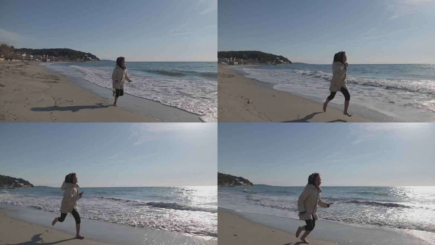 寒假期间，快乐的小女孩在沙滩上奔跑