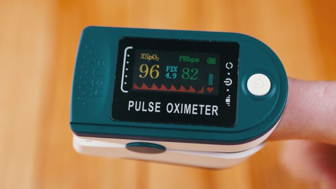 妇女在家用脉搏血氧仪测量脉搏和血氧饱和度