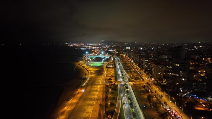 夜间照明巴塞罗那市著名的海滩湾交通街道道路航拍全景4k西班牙