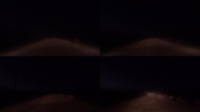 司机的夜景，在空旷的土路上行驶时，挣扎着透过雾看东西，道路两旁都是巨石