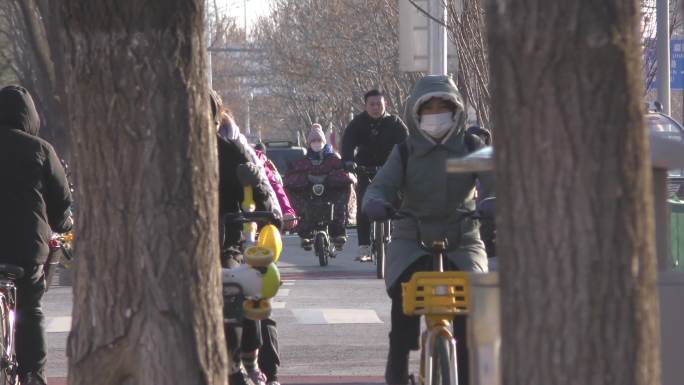 骑行都市生活快递小哥冬天上班送孩子上学