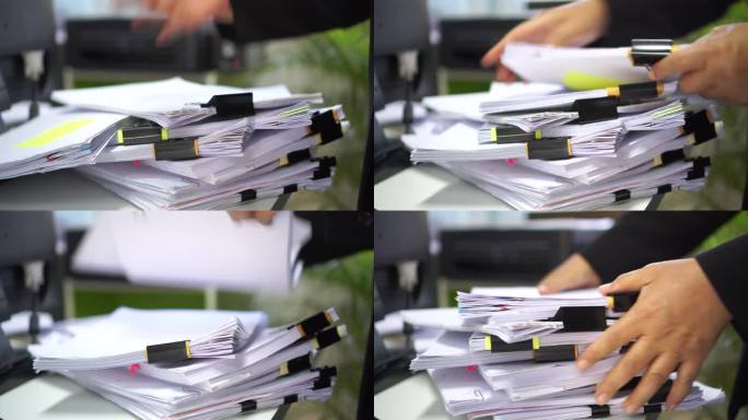 办公人员在繁忙的工作中整理成堆的文件，查找信息，未完成的文件，成堆的审计表格，调查杂乱的财务文件