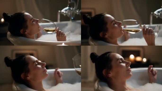 放松的女人在浴缸中饮酒