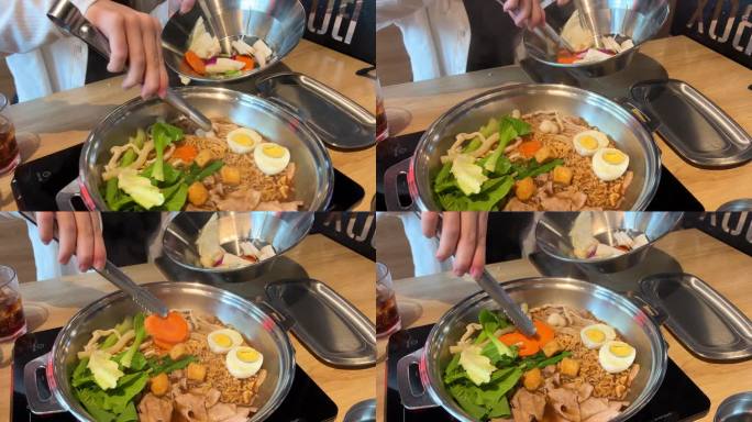 在餐馆里做越南传统汤，自己选食材，放入铁锅里，煮，用面条煮