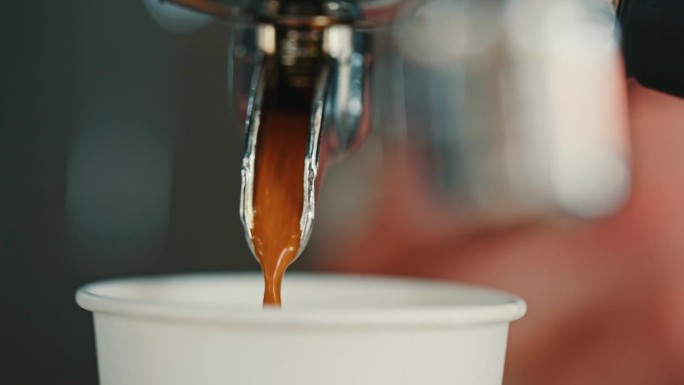 专业咖啡机里的浓缩咖啡开始倒进餐车里的纸杯里
