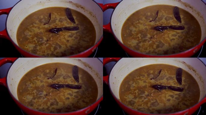 把咖喱放在锅里小火炖，里面放三个红辣椒来增加辣味