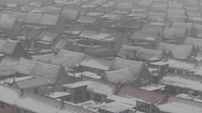 航拍山东荣成俚岛烟墩角村海草房冬季雪景