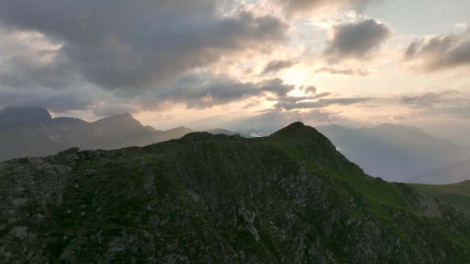 晚霞笼罩的壮丽山顶的特写镜头，与山脉相映成趣，鸟瞰山景