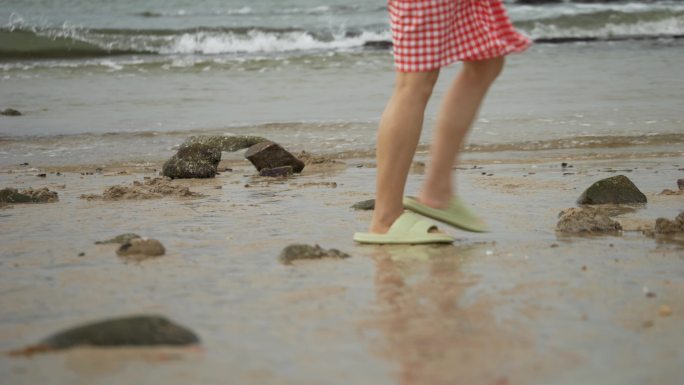 海滩沙滩穿拖鞋的游客