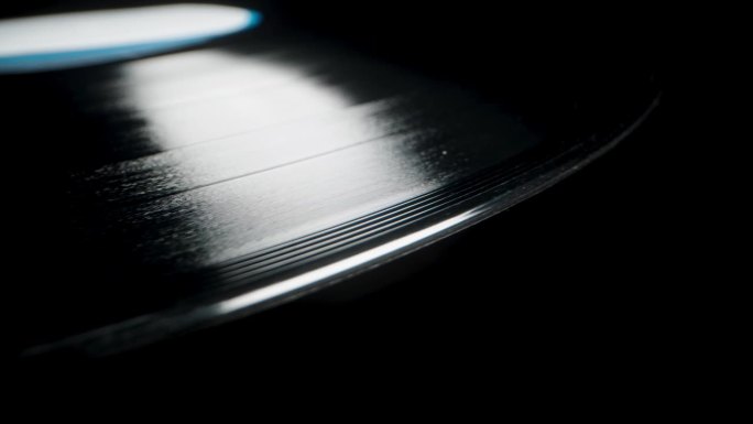 特写显示黑胶唱片上的螺旋槽，黑色背景上的音轨。