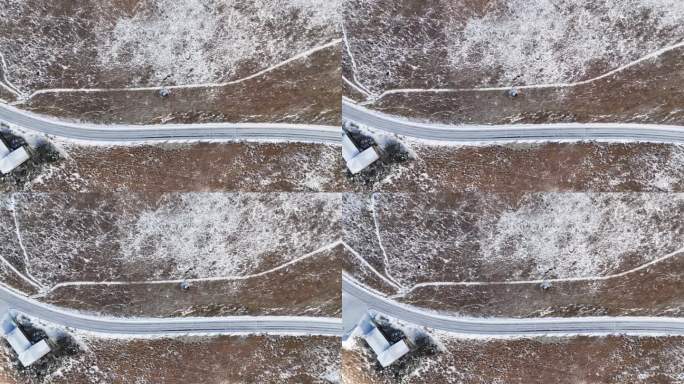 在一个阳光明媚的日子里，鸟瞰白雪覆盖的高原，道路被剩余的雪变白了