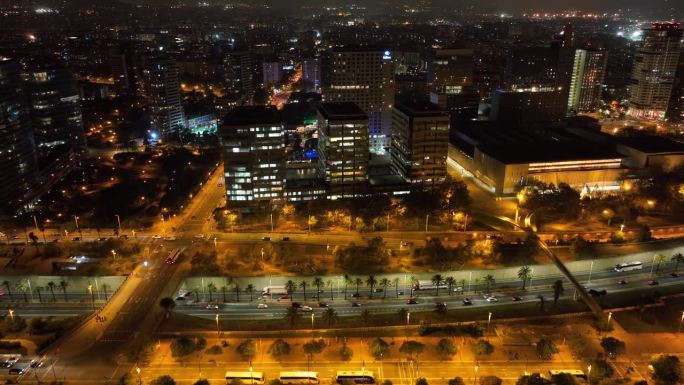 夜晚照亮巴塞罗那市办公大楼交通街道海湾路航拍全景4k西班牙