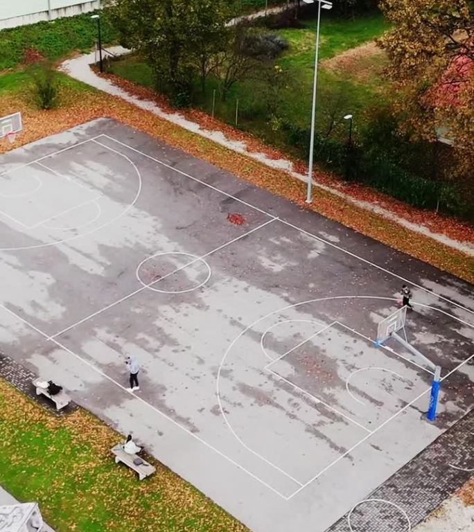 空中无人机拍摄的人们在篮球场和滑板场比赛