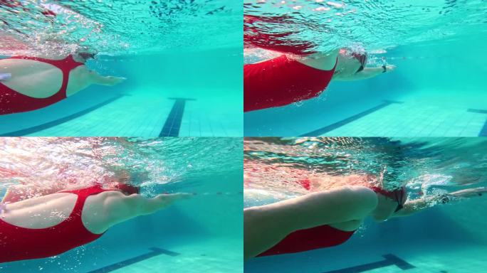 一名女子白天在旅游胜地的游泳池里做自由泳的水下跟踪镜头