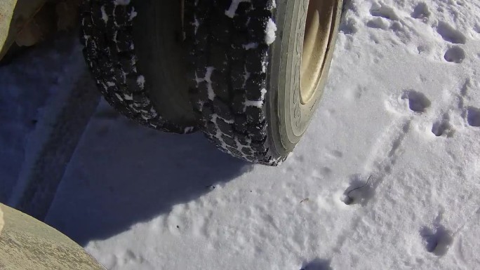 一辆双轮谷物卡车行驶在下雪的农家院子里