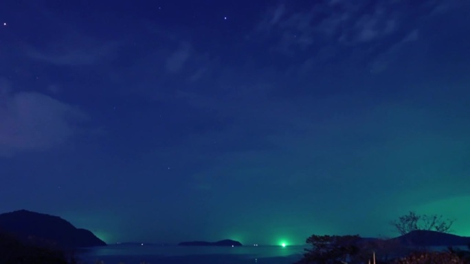 深蓝色的星空，明亮的绿色星光，热带夏季岛屿天堂，平静的海水和海浪