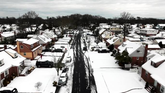 暴风雪覆盖郊区后的鸟瞰图。拍摄于第二天早上，摄像机在低空拍摄，在刚犁过的街道上拍摄。