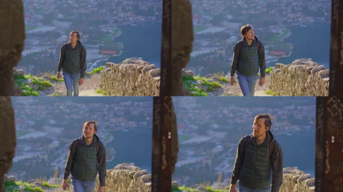 一名男子游客参观黑山的科托尔老城。他正爬上俯瞰全城的圣约翰要塞的楼梯，欣赏着城市的美景。黑山旅行的概