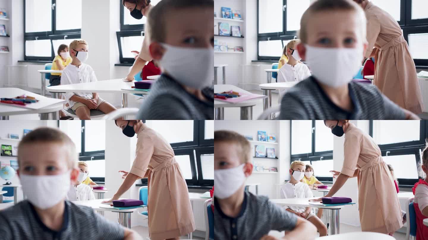 教师和儿童在教室室内戴口罩，消毒课桌。