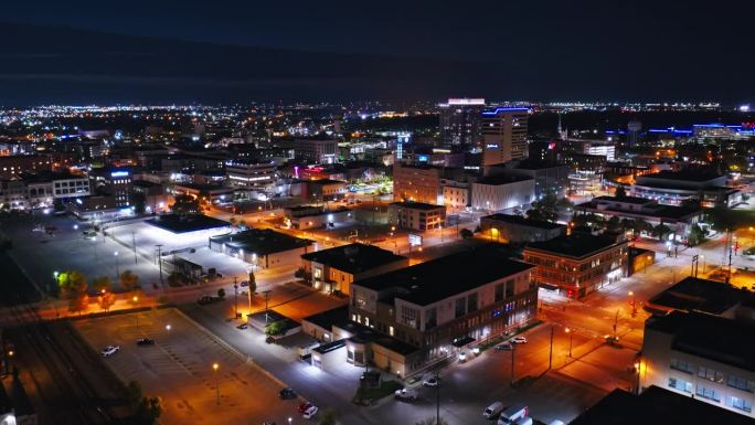 夜间，北达科他州法戈市中心，用左潘向右上升的无人机拍摄