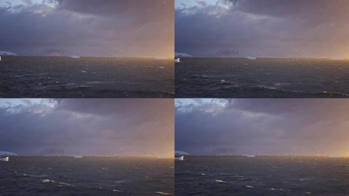 美丽的照片展示了南极海上的日落，蓝色的海浪和黄色的日落在背景中，还有戏剧性的云。