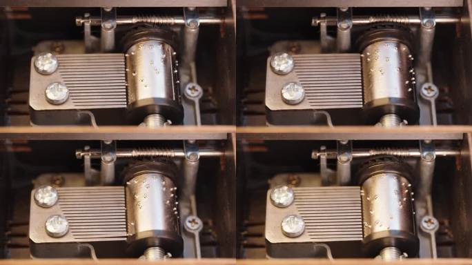 一个古董木制音乐盒的机构特写。老式音乐盒机制，金属针和圆柱播放旋律时，旋转。