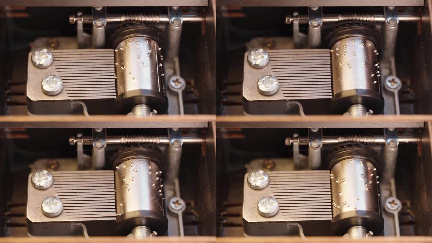 一个古董木制音乐盒的机构特写。老式音乐盒机制，金属针和圆柱播放旋律时，旋转。