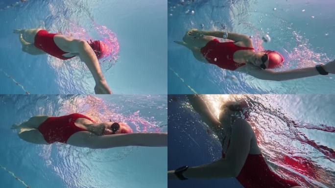在阳光明媚的日子里，坚定的运动女子在游泳池游泳的低角度水下跟踪镜头
