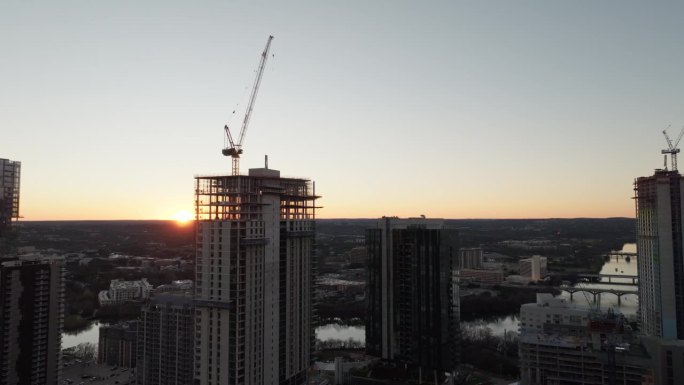 高空起重机在建筑工地建造高层公寓和办公室的航拍照片