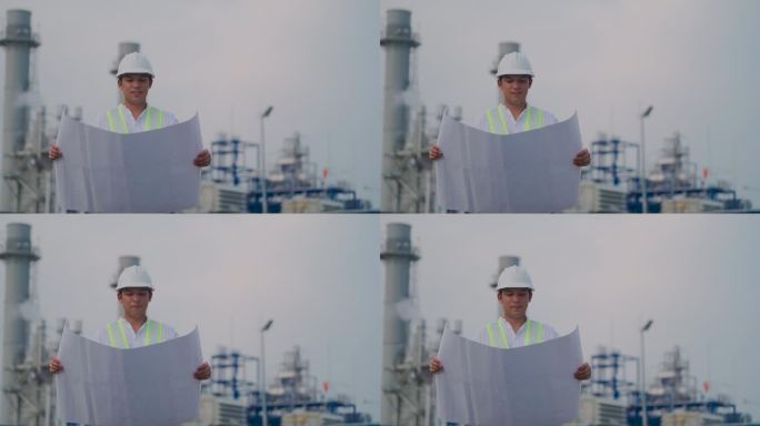 工业工程师戴安全帽，在电厂附近工作，在施工现场检查建筑图纸。