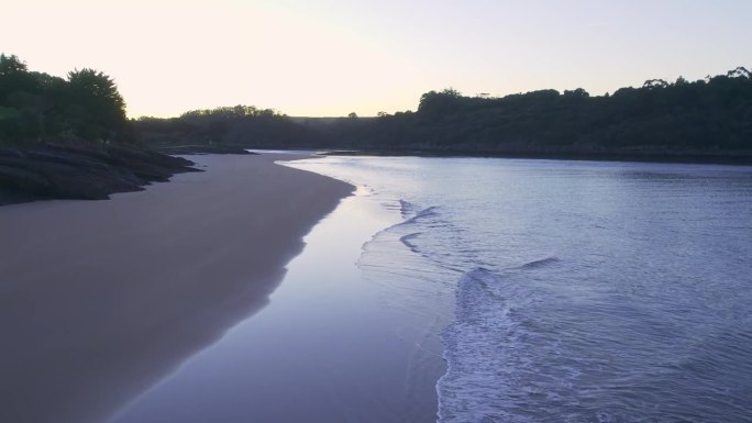 温和的海浪在荒芜的沙滩日落海滩普拉亚德拉竞技场，西班牙航拍