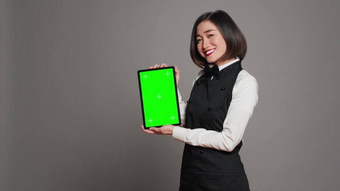 亚洲餐厅女服务员在工作室展示绿幕