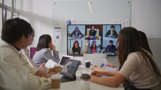 不同的员工在会议室的电视屏幕上进行在线会议视频通话