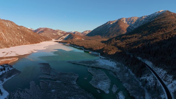 冬天，德国巴伐利亚的西尔万施泰因湖。蓝蓝的水，阿尔卑斯山上的白雪和雪地上的夕阳。这是一架4K超高清无